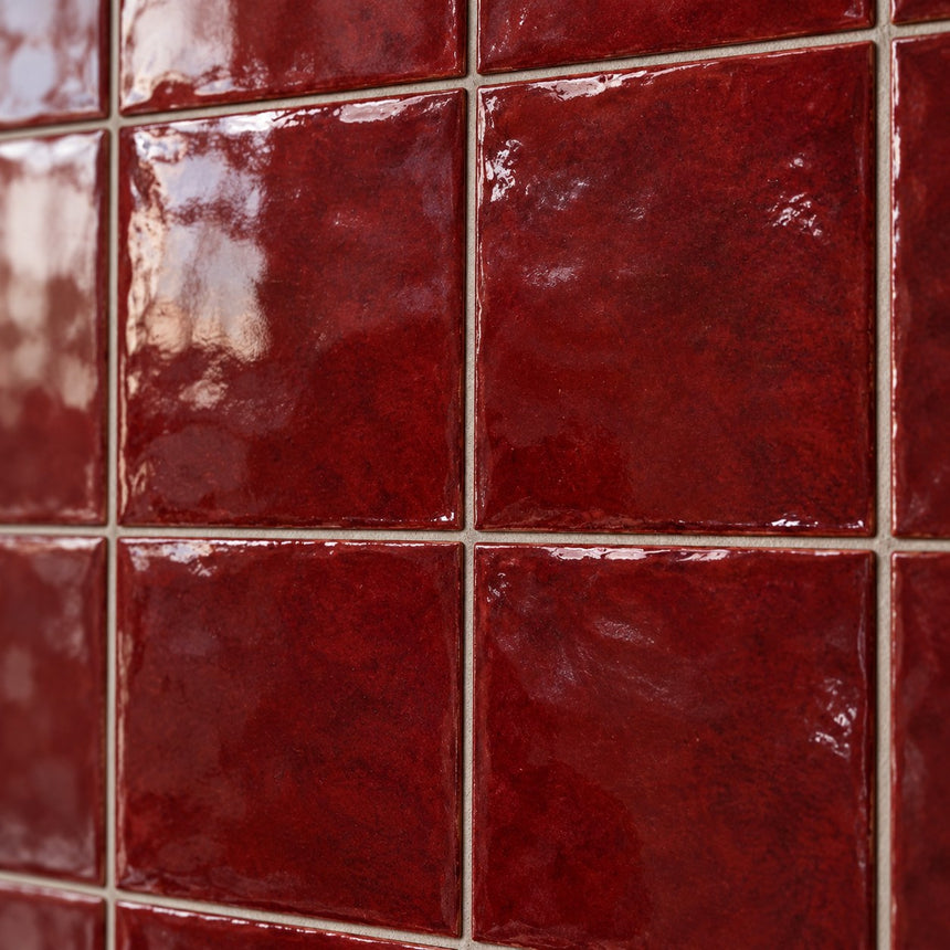 Illustrative AI close-up of Majorca Burgundy Gloss square tile glaze and grout detail